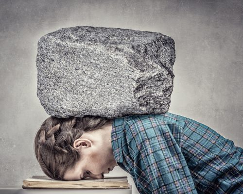 Student girl pressed with stone to opened book pages