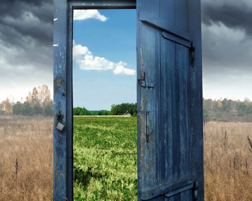 Creative background. Old wooden door, blue color, in the box. Transition to a different climate. The concept of climate change, portal, magic. Copy space.