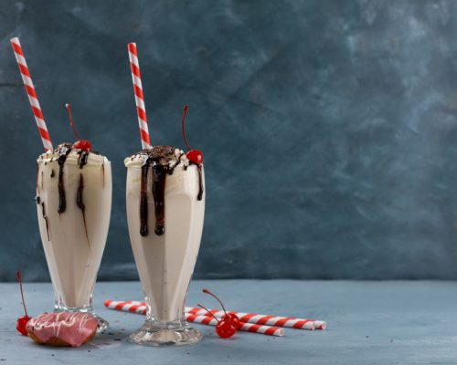 Milkshake (smoothie) with chocolate and cherry in glass, selective focus