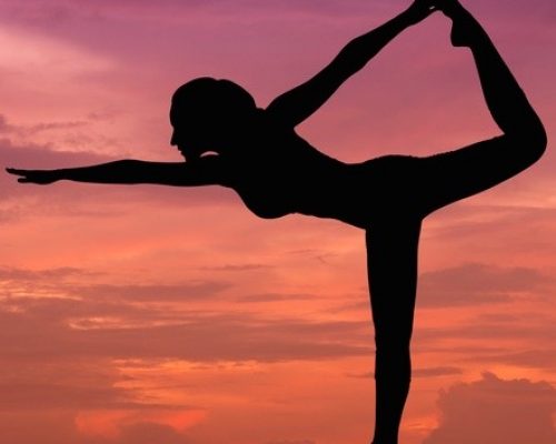 Silhouette of a beautiful Yoga woman at sunset