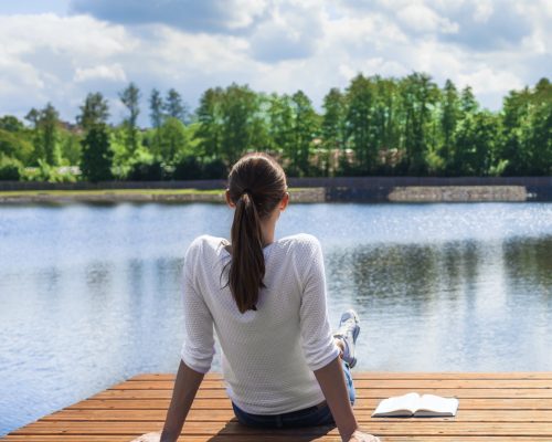 Woman relaxing by a beautiful lake.